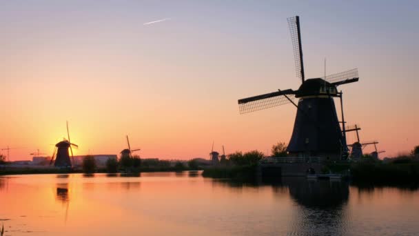 オランダ 劇的な空と水の反射で夕日を過ごすオランダの有名な観光スポットで田舎の風車 — ストック動画