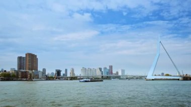 Rotterdam 'ın Nieuwe Maas üzerindeki ufuk çizgisi Erasmusbrug köprüsü ve köprünün altından yük gemilerinin geçtiği gökdelenler. Rottherdam, Hollanda