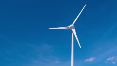 Yeşil yenilenebilir alternatif enerji kavramı - rüzgar jeneratörü türbini gökyüzünde elektrik üretiyor. Önce statik ve sonra yatay kamera tavası