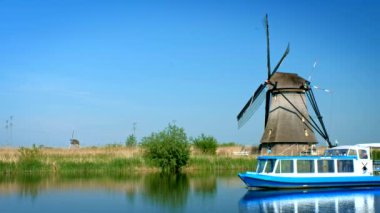 KINDERDIJK, NETHERLANDS - 10 Mayıs 2017: Hollanda 'daki ünlü Kinderdijk turizm sahasında turist botu ve yel değirmenleriyle Hollanda kırsal alanı