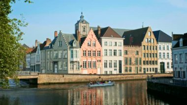 BRUGES, BELGIUM - 28 Mayıs 2018: Ünlü turist kasabası Bruges 'de (Brugge) turist teknesi ve eski evler, Belçika
