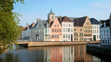 BRUGES, BELGIUM - 28 Mayıs 2018: Ünlü turizm kasabası Bruges 'deki eski evler ve kanallar (Brugge) gün batımında, Belçika