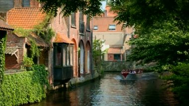 BRUGES, BELGIUM - 28 Mayıs 2018: Belçika 'nın ortaçağ kasabası Bruges' deki kanalda turist botları