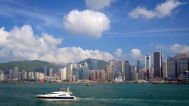 HONG KONG, ÇİN - 1 Mayıs 2018: Hong Kong gökdelenleri şehir merkezi gökdelenleri Victoria Limanı üzerinde gündüz vakti bulutlu tekneyle. Hong Kong, Çin. Yatay kamera görüntüleme