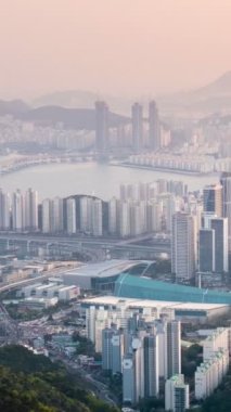 Busan, Güney Kore şehir merkezi Gwangan Köprüsü hava manzaralı gece gündüz. Etkin bir yakınlaşmayla