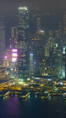 Aydınlatılmış Hong Kong gökdelenlerinin hava zaman çizelgesi şehir merkezindeki gökdelenlerin akşamları. Hong Kong, Çin. Kamera çevirme efekti