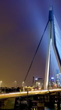 Gece, Nieuwe Maas üzerindeki Erasmus Köprüsü üzerindeki Rotterdam 'da sokak trafiğinin zamanlaması aydınlandı. Rotterdam, Hollanda. Kamera tavası