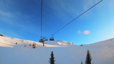 Kablolu sandalyede kayak kaldırmanın birinci şahıs bakış açısı FPV 'nin hızlı ileri etkisi alp kayağı için yükselir. Dolomitler 'de kayak yapan insanlarla kayak pisti. Kayak alanı Belvedere. Canazei, İtalya