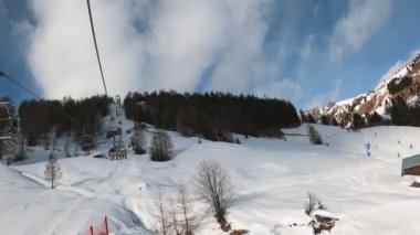Kablolu sandalyede kayak kaldırmanın FPV bakış açısı Dolomitlerde alp kayağı için yükseliyor. İtalya 'da Dolomitler' de kayak yapan insanlarla kayak merkezi. Kayak alanı Belvedere. Canazei, İtalya