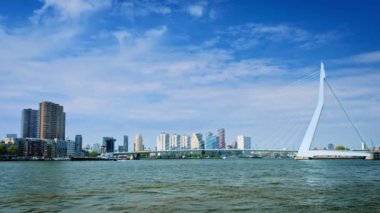 Rotterdam 'ın Nieuwe Maas üzerindeki ufuk çizgisi Erasmusbrug köprüsü ve köprünün altından yük gemilerinin geçtiği gökdelenler. Rotterdam, Hollanda