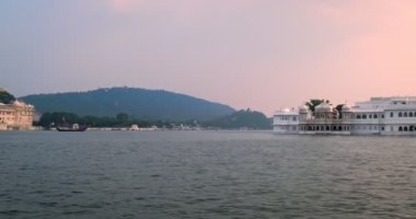 Pichola gölündeki hareket halindeki tekneden Udaipur Şehir Sarayı manzarası. Lüks saray Rajput mimarisi Rajasthan 'ın Mewar Hanedanı hükümdarları ve Hindistan' ın ünlü turist simgesidir. İnanılmaz Hindistan mirası..