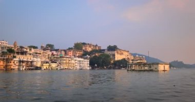Pichola gölündeki hareket halindeki tekneden Udaipur Şehir Sarayı manzarası. Lüks saray Rajput mimarisi Rajasthan 'ın Mewar Hanedanı hükümdarları ve Hindistan' ın ünlü turist simgesidir. İnanılmaz Hindistan mirası..