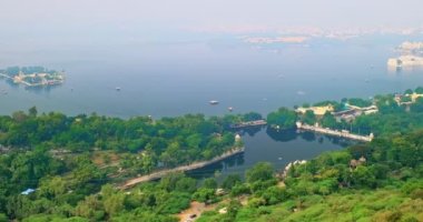 Jag Mandir Lake Garden Palace, Lake Palace (Jag Niwas) ve City Palace ile birlikte Pichola Gölü 'nün hava manzarası ve teleferik halatı yolu. Udaipur, Rajasthan, Hindistan. Yatay kamera tavası