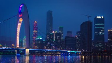 Guangzhou 'nun Zhujiang İnci Nehri üzerindeki Liede Köprüsü manzarası ve geceleri aydınlanan finansal bölgenin modern gökdelenleri. Guangzhou, Çin. Yatay kamera tavası