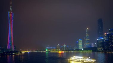 Guangzhou şehri, Pearl Nehri üzerindeki Kanton Kulesi 'nin ufuk çizgisi, akşam panoramasında suda turist tekneleriyle aydınlandı. Guangzhou, Çin