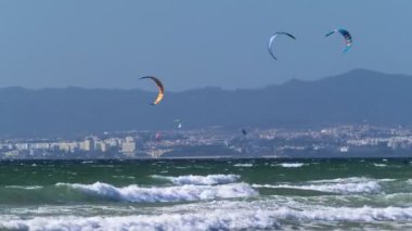 Costa da Caparica, Portekiz - 24 Eylül 2024: Uçurtma sörfü uçurtmaları Fonte da Telha sahilinde Atlantik Okyanusu kıyısında uçurtmalar