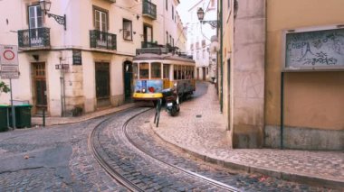 Lizbon, Portekiz - 26 Ağustos 2022: Lizbon, Portekiz 'in Alfama ilçesinin dar sokaklarında ünlü klasik sarı tramvay - Lizbon' un sembolü, ünlü popüler seyahat ve turizm merkezi