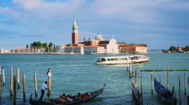 VENICE, ITALY - 27 Haziran 2018: Gondolcu gondolda turistler ve Aziz Mark (San Marco) meydanında Venedik, İtalya 'da arka planda San Giorgio di Maggiore kilisesi olan tekneler.