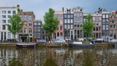 Amsterdam, Hollanda - 22 Mayıs 2018: Amsterdam pitoresk şehir manzarası - kanal boyunca demirli tekneler ve eski evler