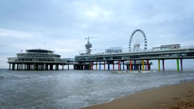 HAGUE, NEHTERLANDS - 13 Mayıs 2017: Scheveningen İskelesi Strandweg, Kuzey Denizi 'nde, Den Haag' da dönme dolabı olan bir sahil. Lahey, Hollanda
