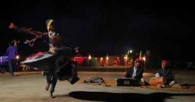 JAISALMER, INDIA - 16 NOVEMBER, 2019: Hintli dansçı - geleneksel kalbelia dansçısı kabile folk müzisyenlerinin Thar Desert Jaisalmer, Rajasthan, Hindistan yakınlarındaki canlı müzikleriyle dans ediyor