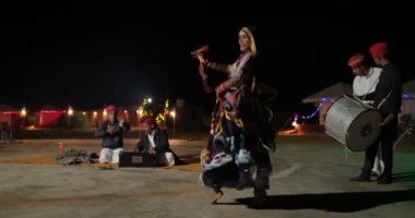 JAISALMER, INDIA - 16 NOVEMBER, 2019: Hintli dansçı - geleneksel kalbelia dansçısı kabile folk müzisyenlerinin Thar Desert Jaisalmer, Rajasthan, Hindistan yakınlarındaki canlı müzikleriyle dans ediyor