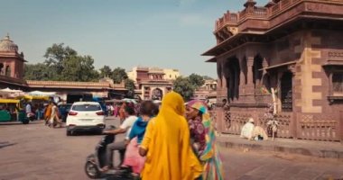 Jodhpur, Hindistan - 14 Kasım 2019: İnsanlar ve araçlar ünlü Rajasthan Kasabası 'ndaki Saat Kulesi yakınlarındaki Sadar pazarında Hint caddesinde trafik. Kamera tavası