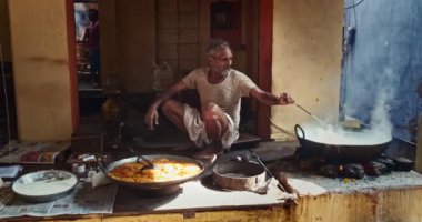 Pushkar, Hindistan - 7 Kasım 2019: Hindistan 'ın Rajasthan kentinde, Pushkar, Rajasthan caddesinde, kaşık tatlı ve haham tatlısı, yoğunlaştırılmış süt tabanlı yemekle karıştırılmış sokak yemekleri tezgahı aşçısı