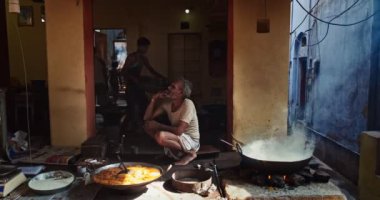 Pushkar, Hindistan - 7 Kasım 2019: Pushkar, Rajasthan, Hindistan 'da tatlı puri ve haham tatlısı, yoğunlaştırılmış süt tabanlı yemek pişirirken sokak yemekleri tezgahı aşçısı