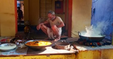 Pushkar, Hindistan - 7 Kasım 2019: Hindistan 'ın Rajasthan kentinde, Pushkar, Rajasthan caddesinde, kaşık tatlı ve haham tatlısı, yoğunlaştırılmış süt tabanlı yemekle karıştırılmış sokak yemekleri tezgahı aşçısı