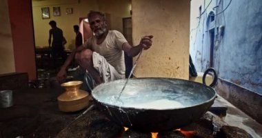 Pushkar, Hindistan - 7 Kasım 2019: Hindistan 'ın Rajasthan kentinde, Pushkar, Rajasthan caddesinde, kaşık tatlı ve haham tatlısı, yoğunlaştırılmış süt tabanlı yemekle karıştırılmış sokak yemekleri tezgahı aşçısı