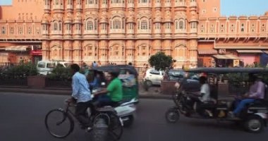 Jaipur, Hindistan - 2 Kasım 2019: İnsanlar, trafik ve şehir ulaşımı ile ünlü tarihi Hawa Mahal Sarayı. Babür kültür mirası, ünlü turist eğlencesi. Kamera eğikliği