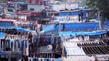 Mumbai, Hindistan - 31 Ekim 2019: Dhobi Ghat Mahalaxmi Dhobi Ghat 'ta çalışan adam Mumbai, Hindistan' da açık hava çamaşırhanesi ve Mumbai 'nin önemli turistik yerlerinde çamaşırları kurutuluyor.