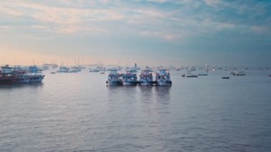 Mumbai, Hindistan - 31 Ekim 2019: Mumbai, Maharashtra, Hindistan 'da gündoğumunda arka planda deniz araçları bulunan turist tekneleri. Yatay kamera tavası