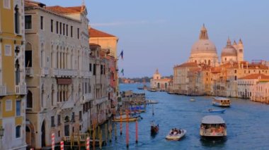 Venedik, İtalya - 19 Temmuz 2019: günbatımında Ponte dell 'Accademia Köprüsü' nden Santa Maria della Salute kilisesine giden gondol ve vaporetto tekneli Venedik Büyük Kanalı manzarası. Kamera tavası