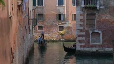 Venedik, İtalya - 19 Temmuz 2019: Venedik, İtalya 'da gondolcu ile turistli gondolcu arasında dar bir kanal