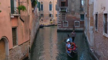 Venedik, İtalya - 19 Temmuz 2019: Venedik, İtalya 'da gondolcu ile turistli gondolcu arasında dar bir kanal