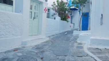 MYKONOS, GREECE - 29 Mayıs 2019: Yunanistan 'ın ünlü Mykonos Adası' ndaki Mykonos kasabasının mavi pencereli geleneksel beyazlatılmış evleri ile manzaralı caddelerde Steadycam steadicam yürüyüşü