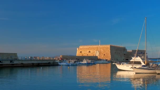 ヘラクライオン Greece 2019年5月18日 ヘラクライオンにあるヴェネツィアの砦の城と 日没にギリシャのクレタ島 モーニングフィッシングボート 横カメラ — ストック動画