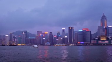 Hong KONG, ÇİN - 28 Nisan 2018: Hong Kong gökdelenleri Victoria Limanı üzerindeki şehir merkezi gökdelenleri turist botları ile aydınlatıldı. Hong Kong, Çin. Kamera tavası
