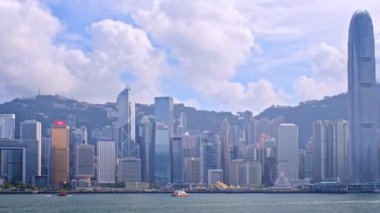 HONG KONG, ÇİN - 1 Mayıs 2018: Hong Kong gökdelenleri şehir merkezi gökdelenleri Victoria Limanı üzerinde günbatımında turist botu ve feribot ile. Kamera tavası