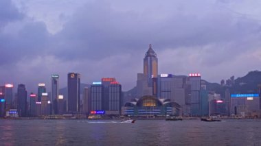 Hong KONG, ÇİN - 28 Nisan 2018: Hong Kong gökdelenleri Victoria Limanı üzerindeki şehir merkezi gökdelenleri turist botları ile aydınlatıldı. Hong Kong, Çin