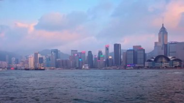 Hong Kong, Çin - 28 Nisan 2018: Hong Kong şehir merkezi gökdelenleri Victoria Limanı üzerinde akşamları turist botu ve feribot ile birlikte. Hong Kong, Çin. Kamera tavası