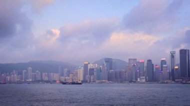 Hong Kong, Çin - 28 Nisan 2018: Hong Kong şehir merkezi gökdelenleri Victoria Limanı üzerinde akşamları turist botu ve feribot ile birlikte. Hong Kong, Çin. Kamera tavası