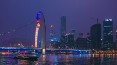 GuanGZHOU, ÇİN - 25 Mayıs 2018: Guangzhou şehir silueti Pearl Nehri üzerindeki Liede Köprüsü ile akşam panoramasında su üzerinde turist botlarıyla aydınlatıldı. Guangzhou, Çin