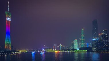 GuANGZHOU, ÇİN - 25 Mayıs 2018: Guangzhou manzaralı Canton kulesi ve Zhujiang İnci Nehri üzerindeki Liede Köprüsü, turist botları ve modern gökdelenler gece aydınlandı