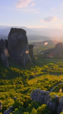 Yunanistan 'ın ünlü Yunan turizm beldesi Meteora' da, Rousanou manastırı ve St. Nicholas Anapavsa Manastırı 'nın üzerinde gün batımı güneş ışınları ve merceklerle parlıyor. Yatay kamera tavası