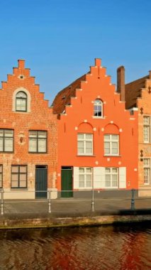 Belçika 'nın ünlü turist kasabası Bruges' de (Brugge) gün batımında eski evler ve kanallar. Kamera tavasıyla