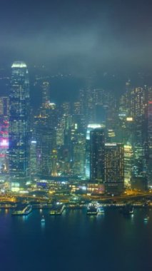 Aydınlatılmış Hong Kong gökdelenlerinin hava zaman çizelgesi şehir merkezindeki gökdelenlerin akşamları. Hong Kong, Çin. Kamera döndürme