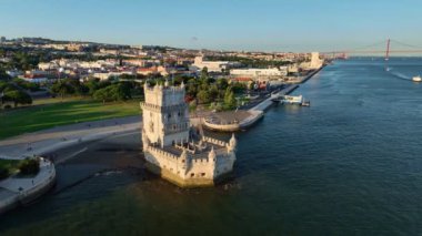 Belem Kulesi 'nin hava aracı görüntüsü Lisboa' nın ünlü turistik beldesi ve Tagus Nehri kıyısında gün batımında turist botu ile turizm merkezi. Lizbon, Portekiz. Kamyon kaydırak atışı